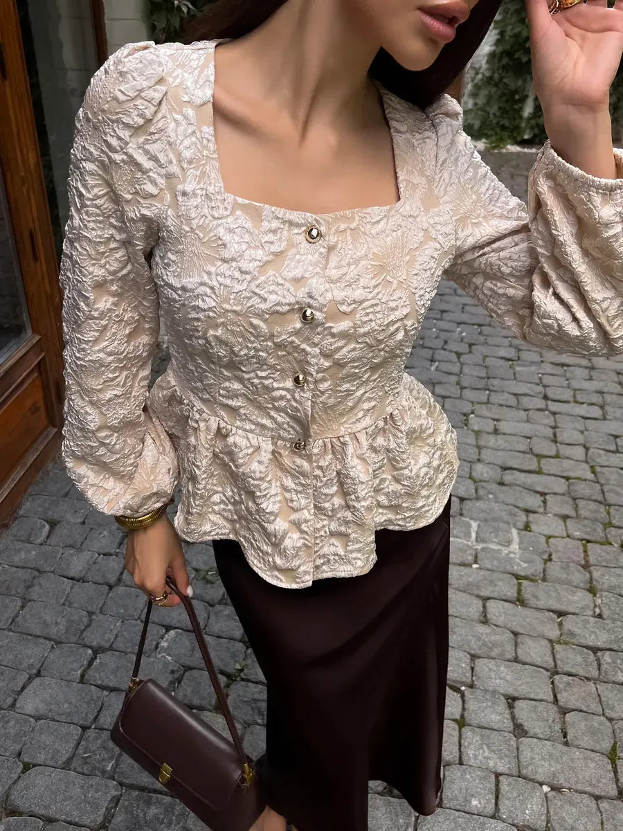 Beige floral jacquard blouse with a peplum hem