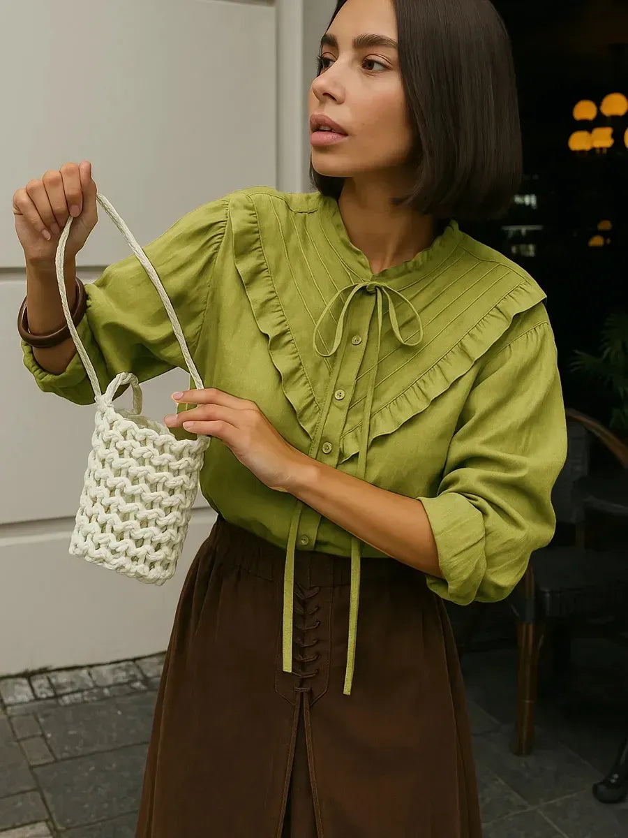 Olive green blouse with billowing sleeves and a tie-neck detail