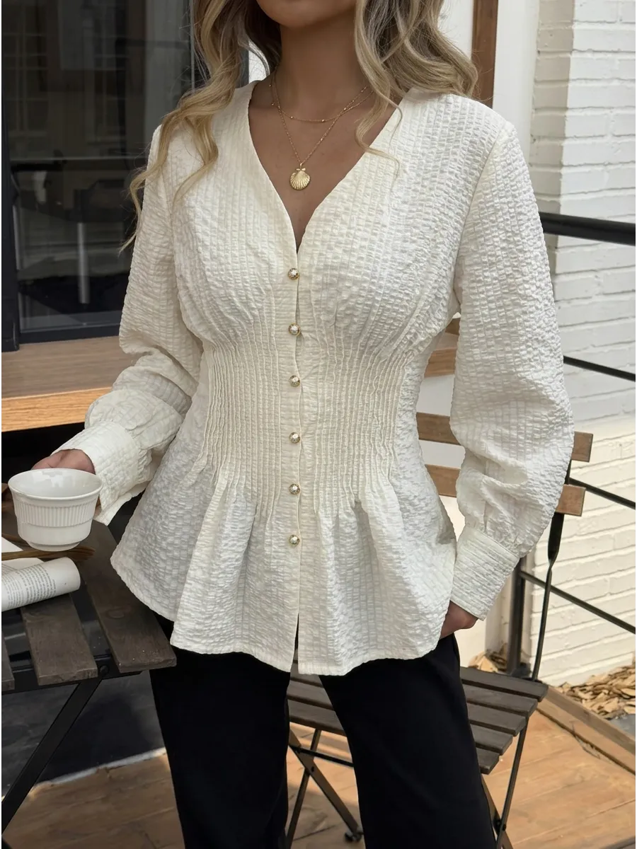 Texture and gathered waist detail of the white fitted blouse